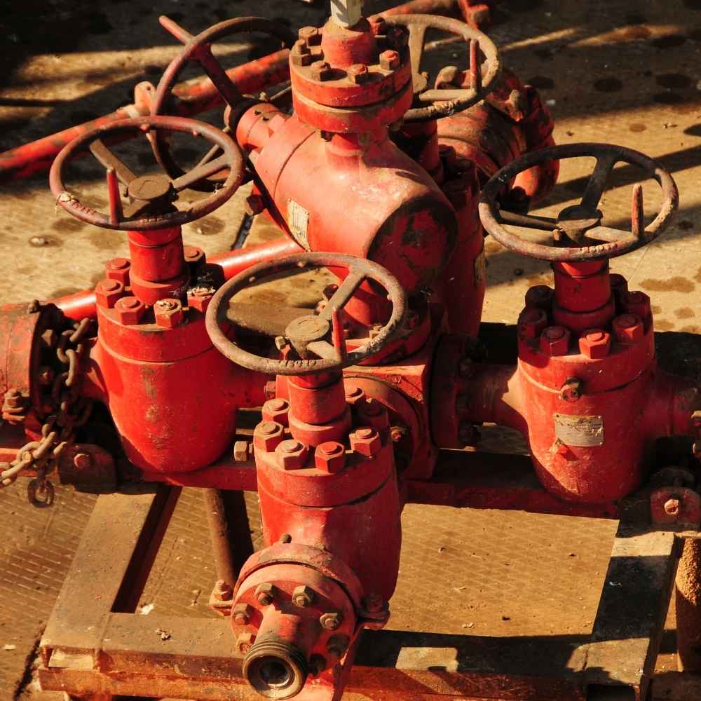 Untitled design - 2026-05-10T141321735 - rawatflowline.com Close-up of red industrial valves with circular handwheels on a rusty piping system.
