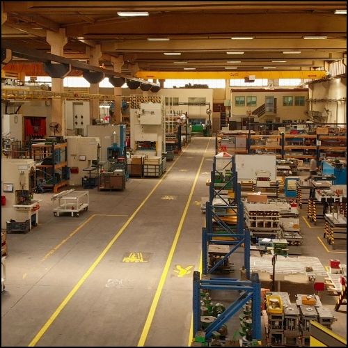 AR Engineering Services 12 - rawatflowline.com Factory floor with rows of machines and shelves, yellow safety lanes, and an elevated viewpoint.